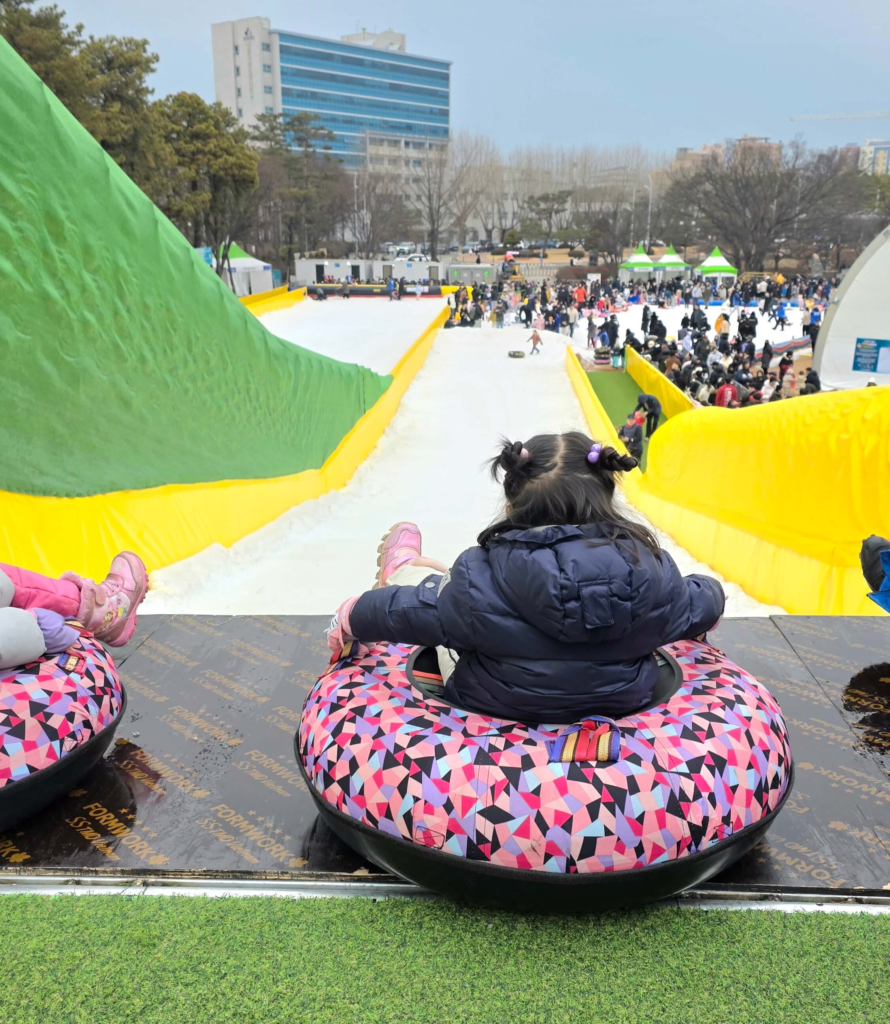 Children sledding at a public winter playground in Seoul