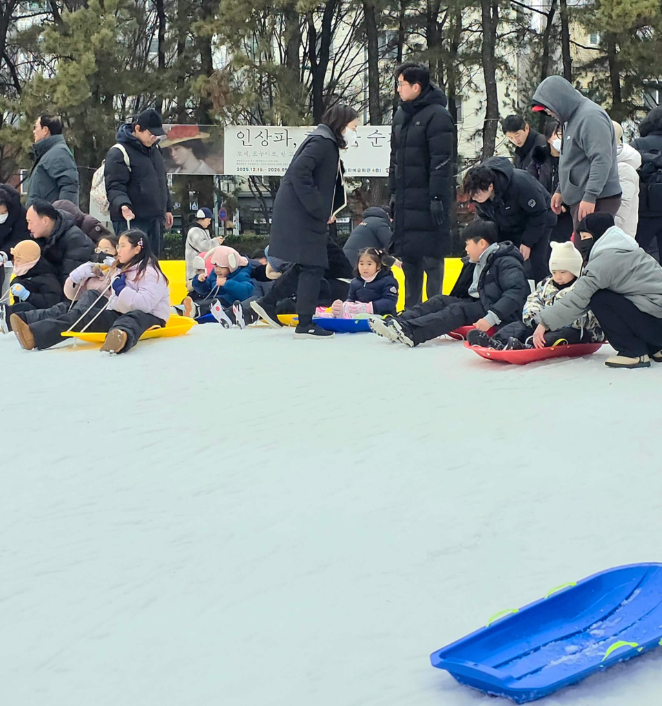 Kids enjoying a sledding hill at SeoulTech campus in winter