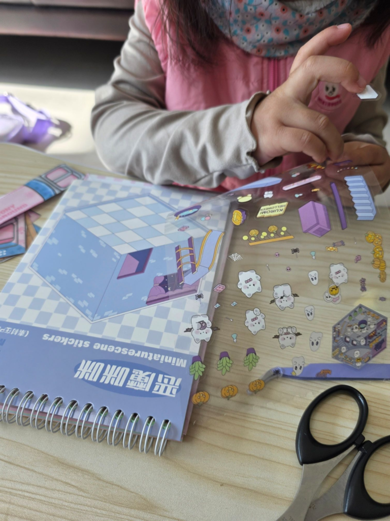 Child peeling a miniature 3D sticker from the sheet