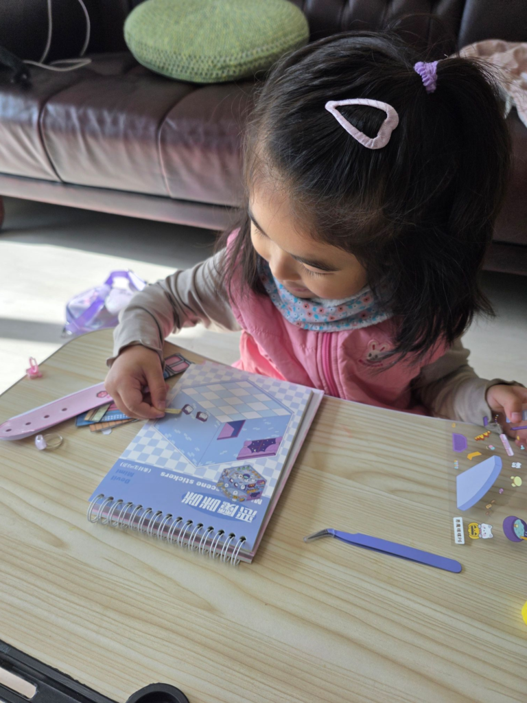 child attaching miniature 3D stickers