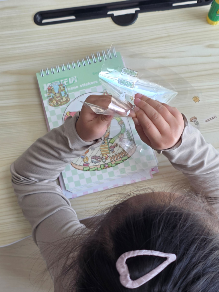 Child peeling a miniature 3D sticker from the sheet
