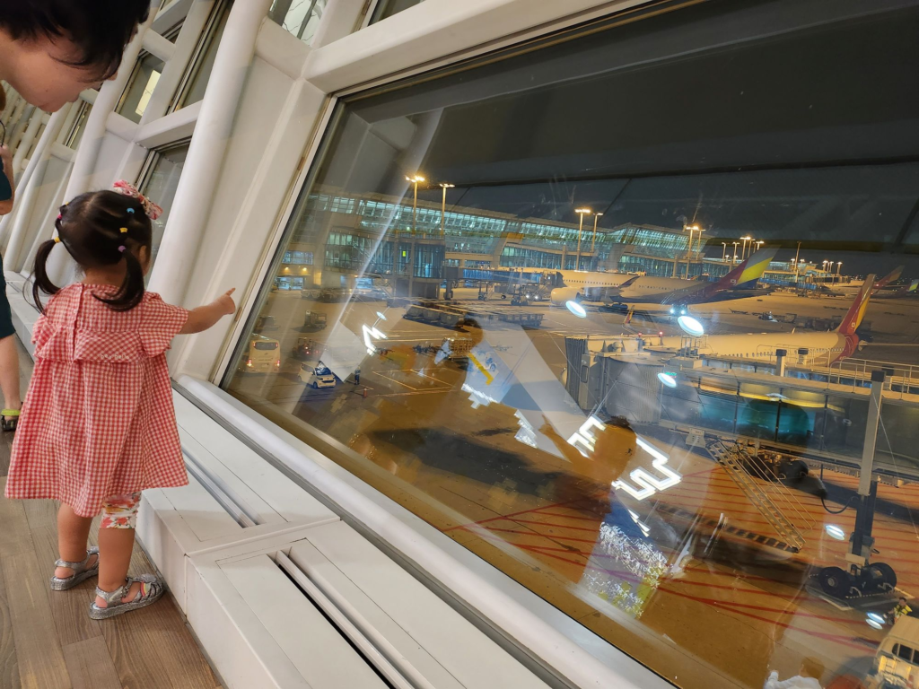 child excitedly watching airplanes at the airport