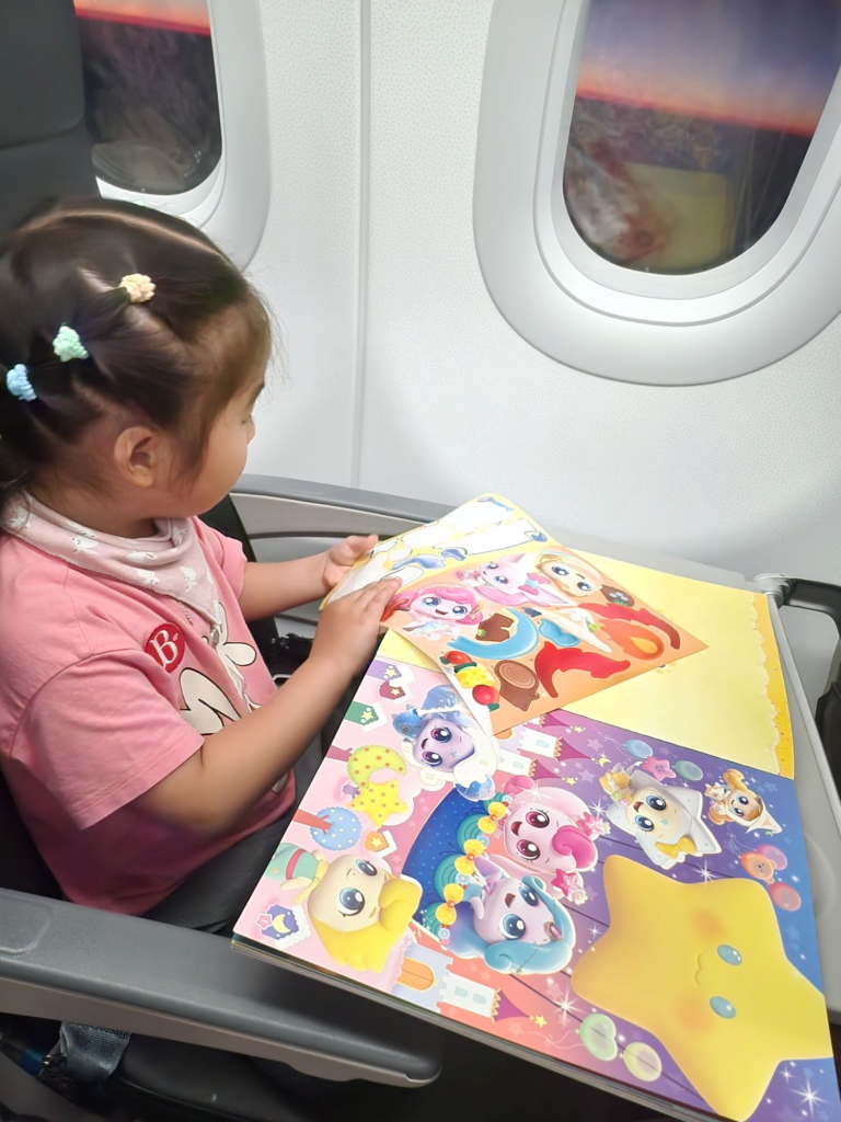 toddler doing sticker activities on an airplane