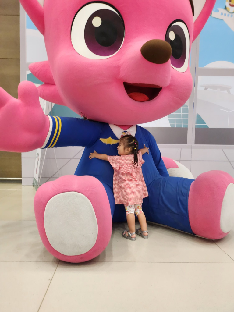 child enjoying Pinkfong toys at the airport play area