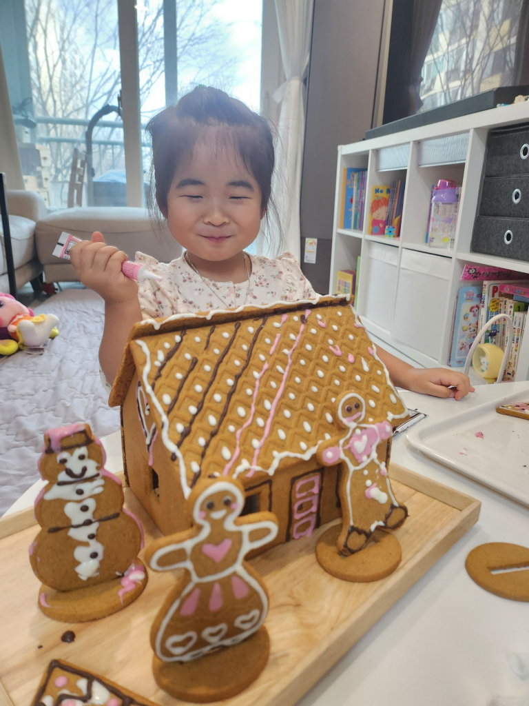 child happily decorating cookies with chocolate pens