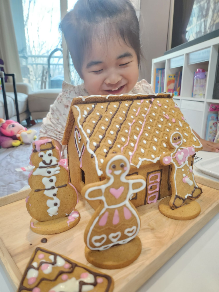kid smiling while decorating cookies with chocolate