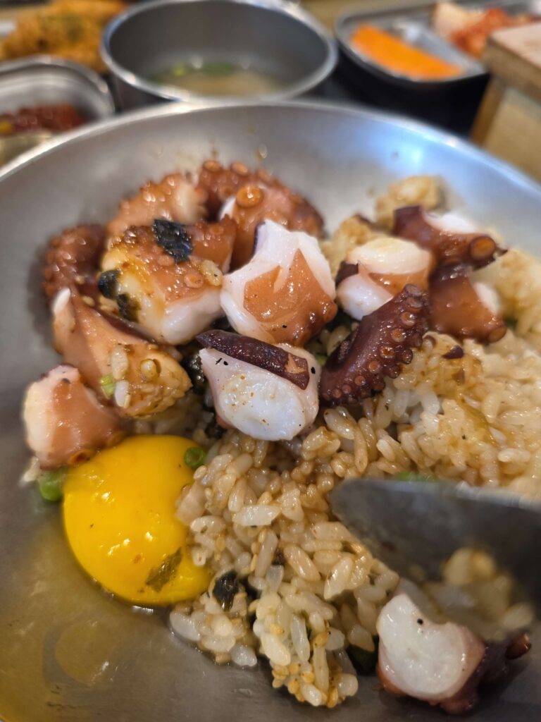 mixing sotbap Korean pot rice in a bowl with sauce