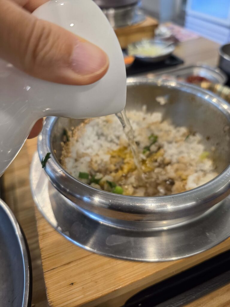 pouring hot water into pot to make nurungji Korean scorched rice